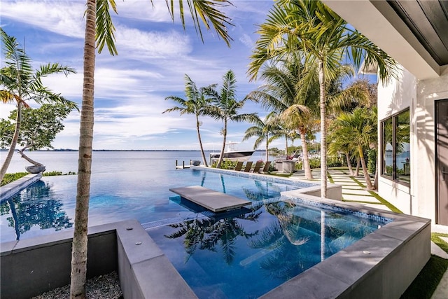 view of swimming pool featuring a jacuzzi and a water view