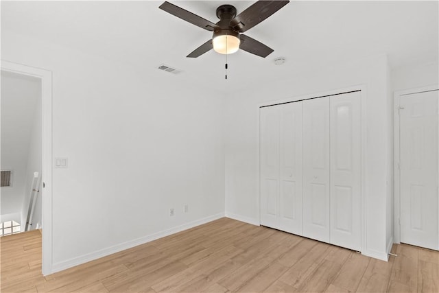 unfurnished bedroom with visible vents, a closet, light wood-style flooring, and baseboards