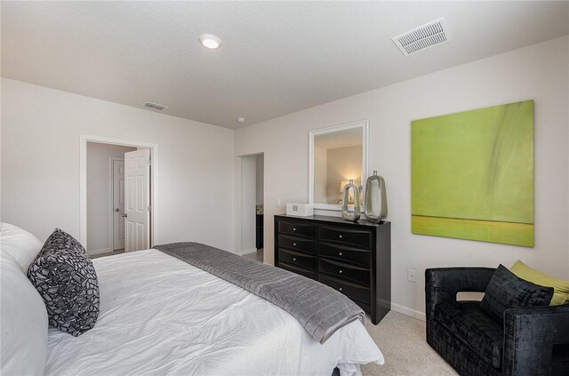 bedroom featuring visible vents, baseboards, and carpet