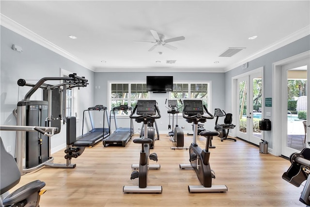 workout area with light wood finished floors, french doors, a wealth of natural light, and crown molding