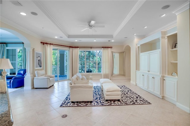 110 Island Plantation Ter Unit 201, Vero Beach, FL 32963 - living room with arched walkways, a ceiling fan, a raised ceiling, light tile patterned floors, and ornamental molding