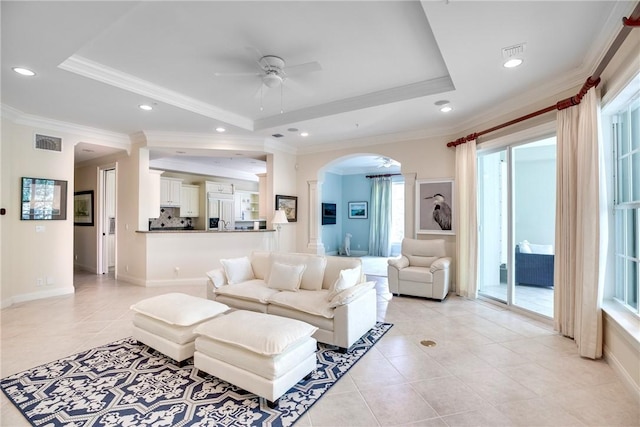 110 Island Plantation Ter Unit 201, Vero Beach, FL 32963 - living area with a tray ceiling, ceiling fan, light tile patterned floors, ornamental molding, and arched walkways