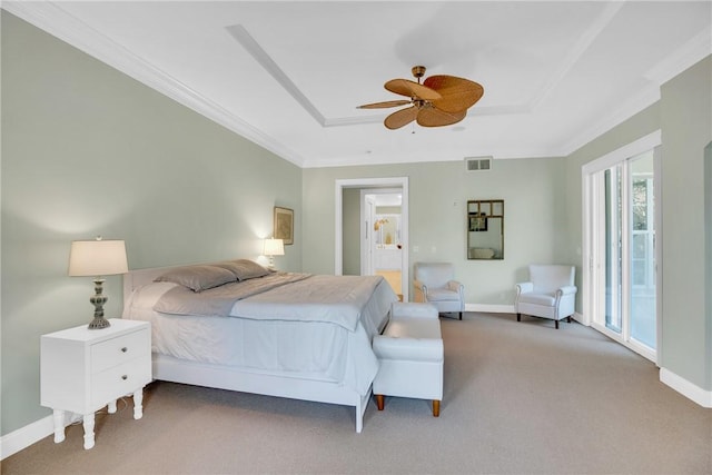 bedroom with carpet floors, visible vents, a tray ceiling, and ornamental molding