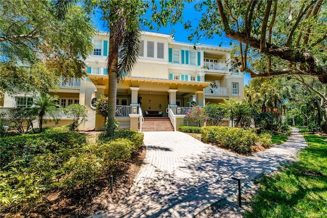 townhome / multi-family property with covered porch and stucco siding