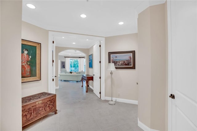 hallway with arched walkways, baseboards, and recessed lighting