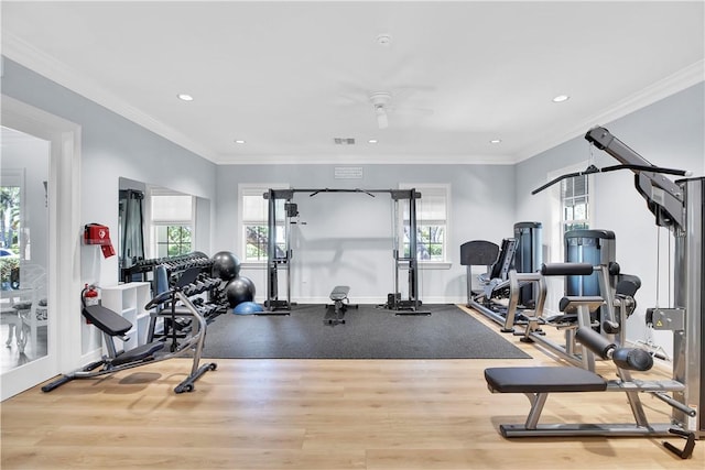 workout room featuring visible vents, crown molding, baseboards, and wood finished floors