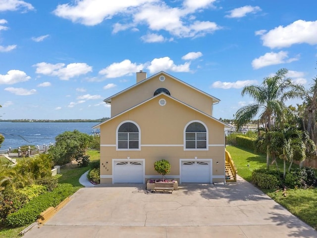 8820 44th Ave, Sebastian, FL 32958 - view of front of home with driveway, a garage, a water view, stairway, and a chimney