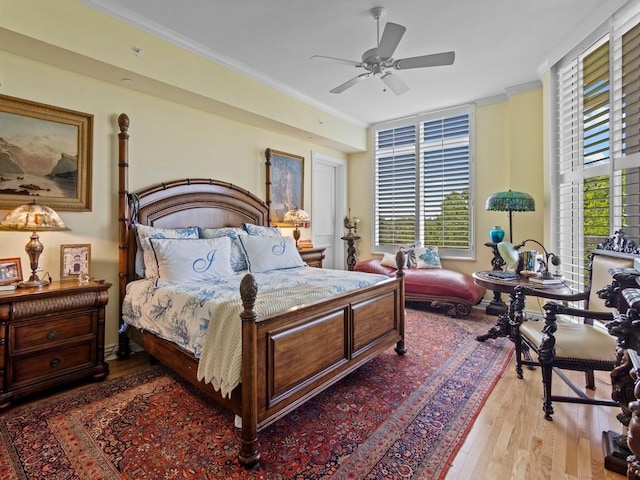 bedroom with crown molding, wood finished floors, and ceiling fan