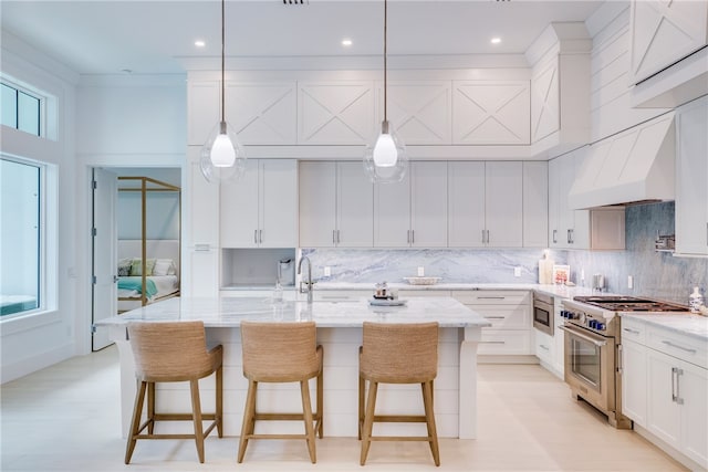 kitchen with light stone countertops, appliances with stainless steel finishes, hanging light fixtures, and plenty of natural light