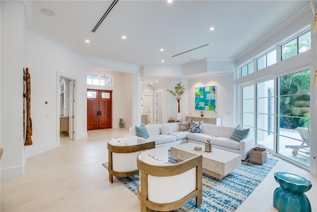 living room featuring light wood-type flooring and ornamental molding