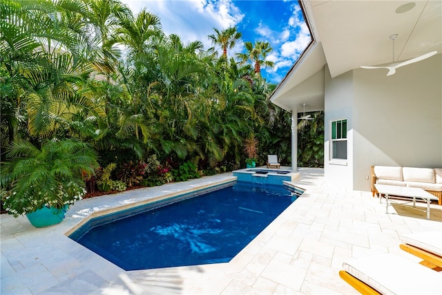 view of swimming pool with ceiling fan, a patio, and an in ground hot tub