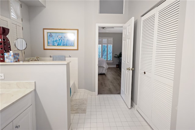 bathroom featuring tile patterned flooring, vanity, ceiling fan, and a tub to relax in