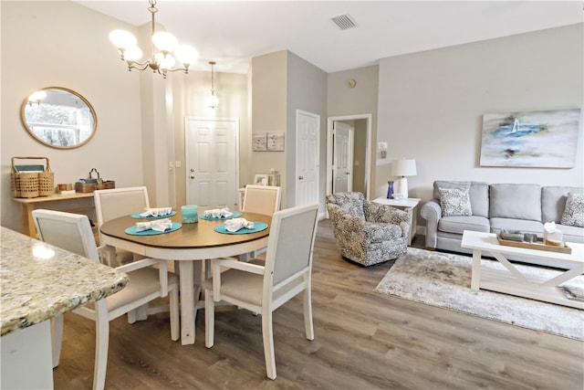 dining room with hardwood / wood-style flooring and a chandelier