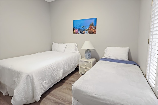 bedroom with hardwood / wood-style floors and multiple windows