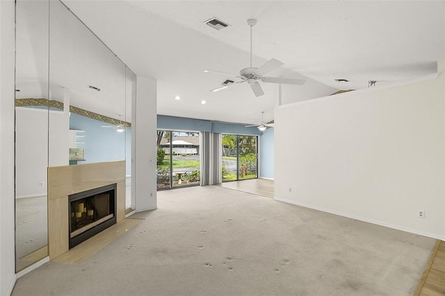 723 Timber Ridge Trl SW Unit B, Vero Beach, FL 32962 - unfurnished living room featuring lofted ceiling, ceiling fan, a fireplace with flush hearth, and light colored carpet