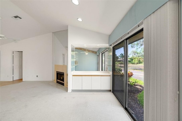 723 Timber Ridge Trl SW Unit B, Vero Beach, FL 32962 - unfurnished living room featuring a fireplace with flush hearth, vaulted ceiling, recessed lighting, and light carpet