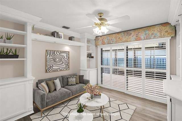 723 Timber Ridge Trl SW Unit B, Vero Beach, FL 32962 - living room with light wood-type flooring, ceiling fan, built in features, and crown molding