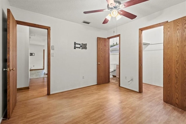 233 13th St SW, Vero Beach, FL 32962 - unfurnished bedroom with a spacious closet, light wood finished floors, baseboards, and a closet