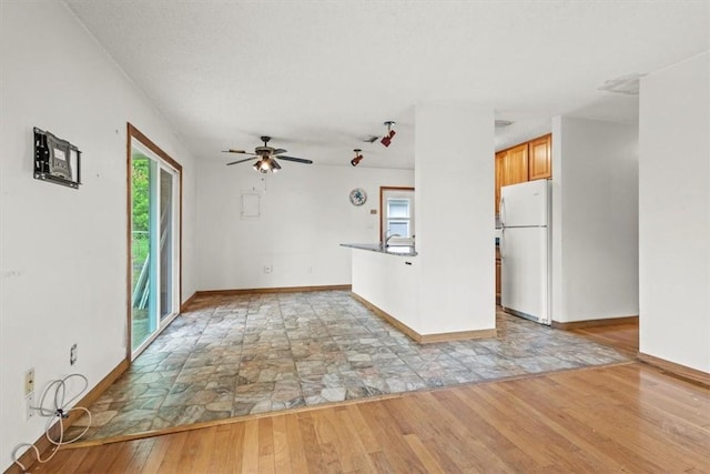 233 13th St SW, Vero Beach, FL 32962 - unfurnished living room with light wood-style flooring, baseboards, and ceiling fan