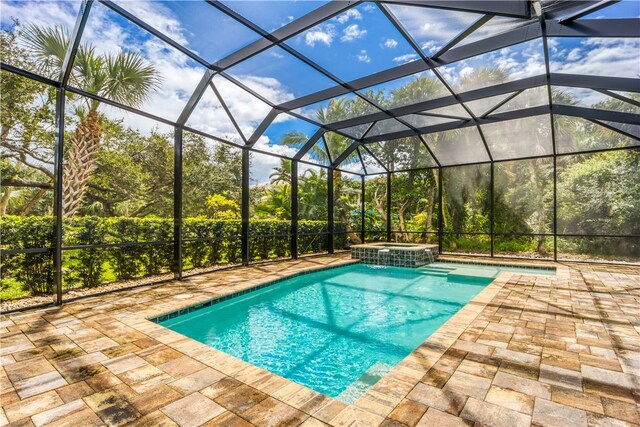 view of pool featuring a patio area, a lanai, and an in ground hot tub