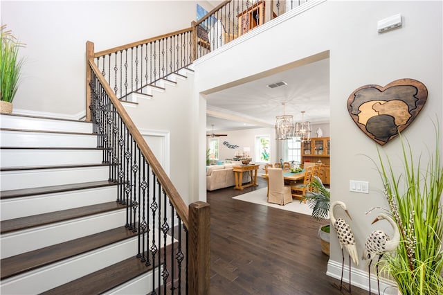 staircase featuring hardwood / wood-style flooring and an inviting chandelier