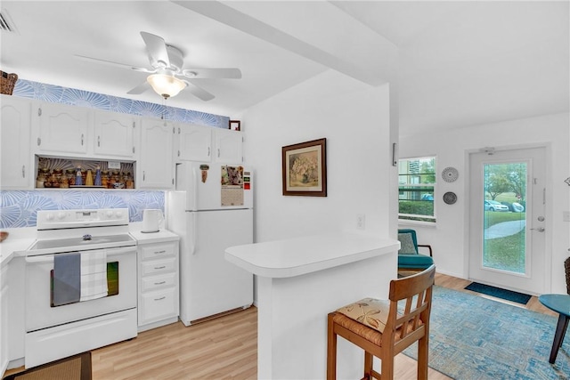 kitchen featuring a breakfast bar, light countertops, white cabinetry, white appliances, and a peninsula