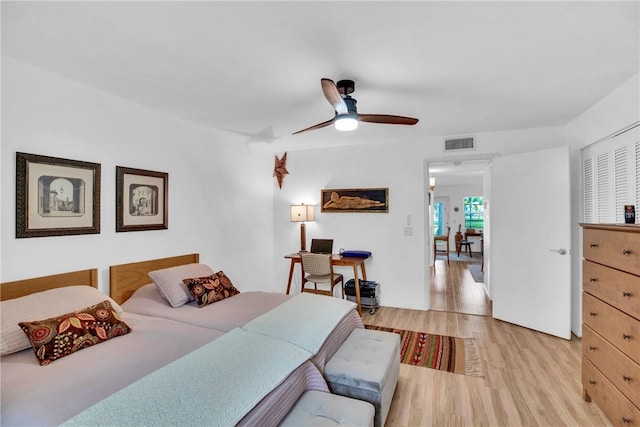 bedroom with a ceiling fan, visible vents, and light wood-style flooring