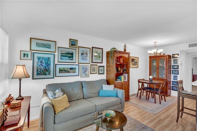 living room with a chandelier, visible vents, light wood-style flooring, and baseboards