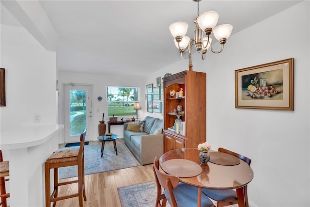 dining room with light wood finished floors and a notable chandelier