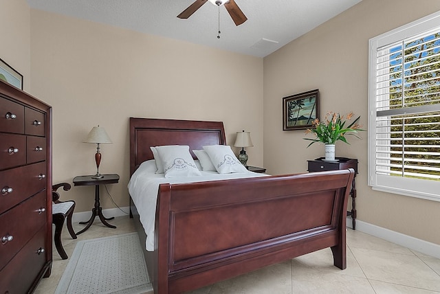 tiled bedroom with ceiling fan and a textured ceiling