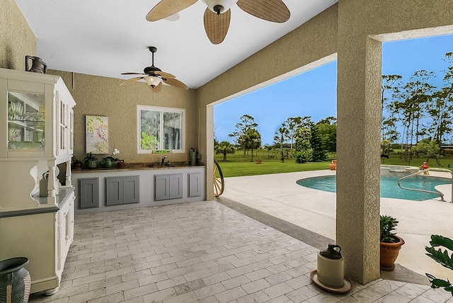 view of swimming pool featuring a patio, sink, and ceiling fan