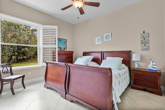 bedroom featuring lofted ceiling, multiple windows, light tile patterned floors, and ceiling fan