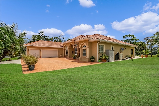 mediterranean / spanish house with a garage and a front yard