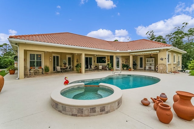 back of house featuring a patio and a pool with hot tub