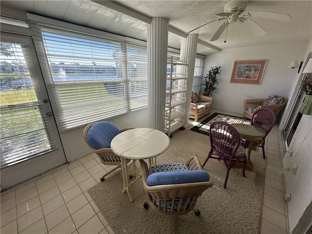 sitting room featuring ceiling fan, light tile patterned floors, and a textured ceiling