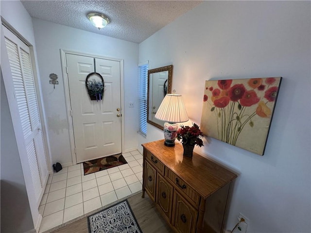 tiled foyer entrance featuring a textured ceiling