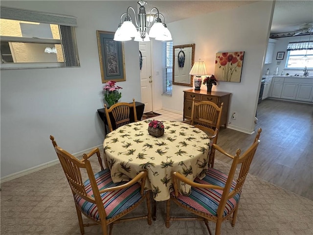 dining area with hardwood / wood-style floors, sink, and a chandelier