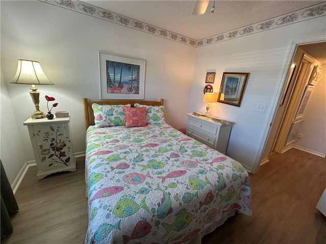 bedroom featuring a textured ceiling, hardwood / wood-style flooring, and ceiling fan