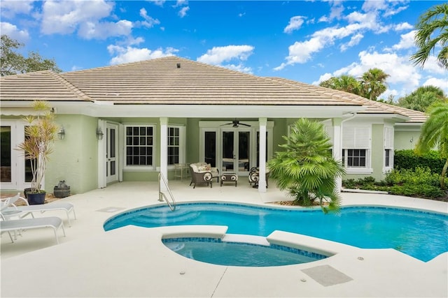 rear view of property with french doors, ceiling fan, a pool with hot tub, and a patio