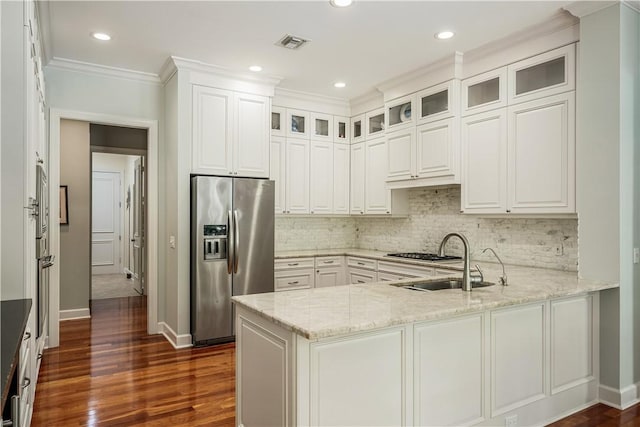 kitchen featuring sink, light stone counters, white cabinetry, appliances with stainless steel finishes, and kitchen peninsula