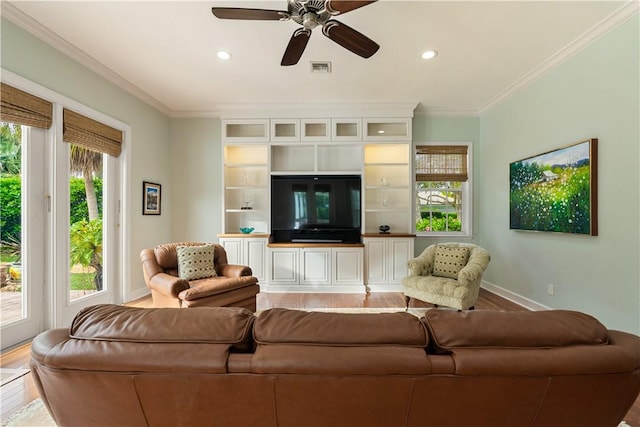 living room featuring hardwood / wood-style floors, crown molding, and ceiling fan