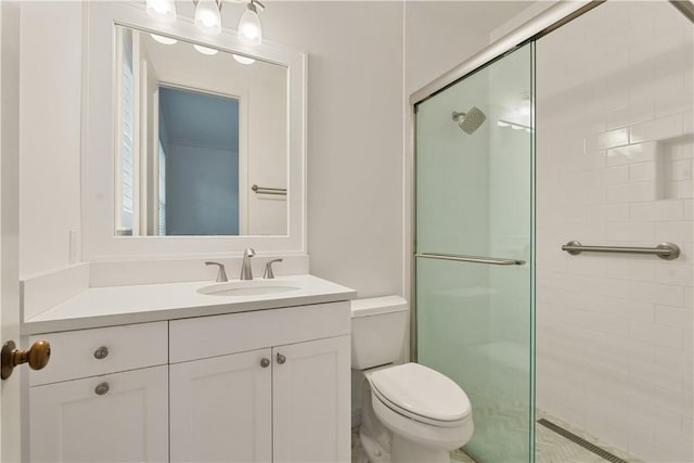 bathroom with vanity, a shower with shower door, and toilet