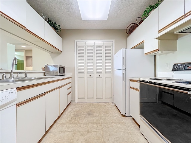 kitchen with white cabinets, white appliances, a textured ceiling, and sink