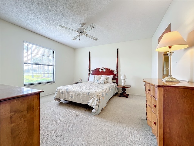 carpeted bedroom with ceiling fan and a textured ceiling