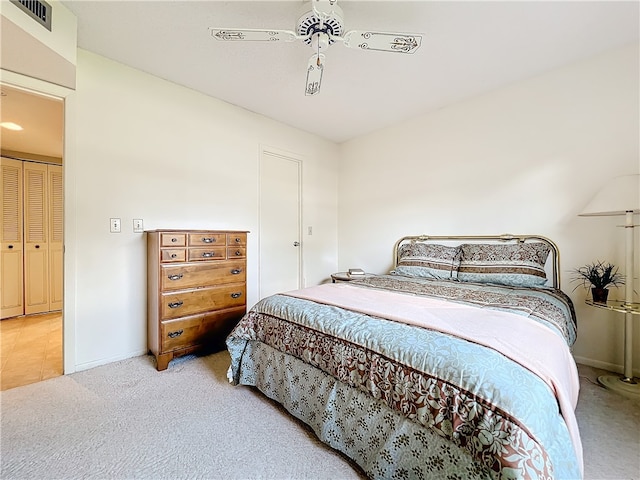 bedroom featuring ceiling fan, light carpet, and a closet