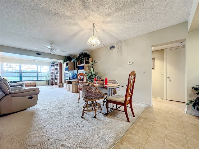 dining space with ceiling fan, a textured ceiling, and light tile patterned floors