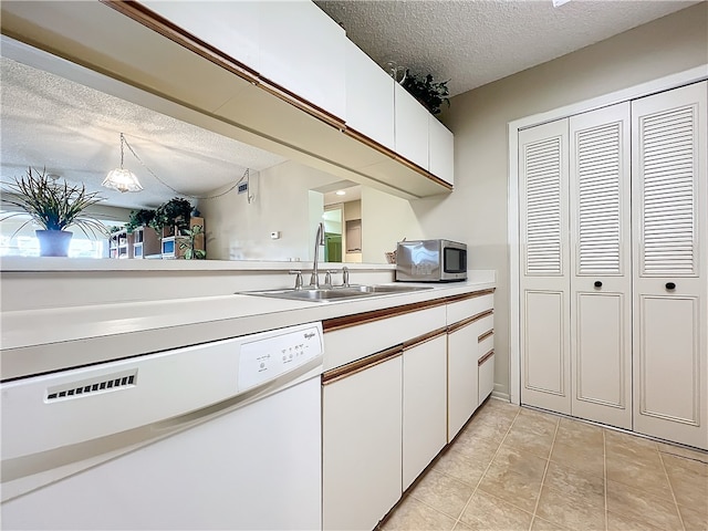 kitchen featuring white cabinetry, a textured ceiling, hanging light fixtures, sink, and dishwasher