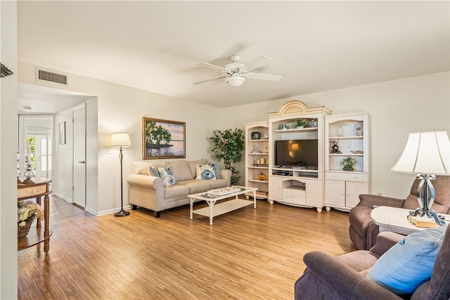 living area featuring a ceiling fan, visible vents, light wood-style flooring, and baseboards