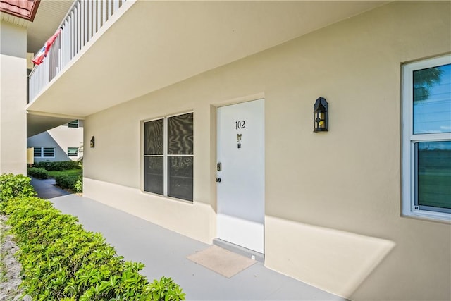 doorway to property featuring stucco siding