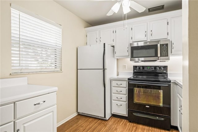 kitchen featuring white cabinetry, electric range, white refrigerator, and light hardwood / wood-style floors